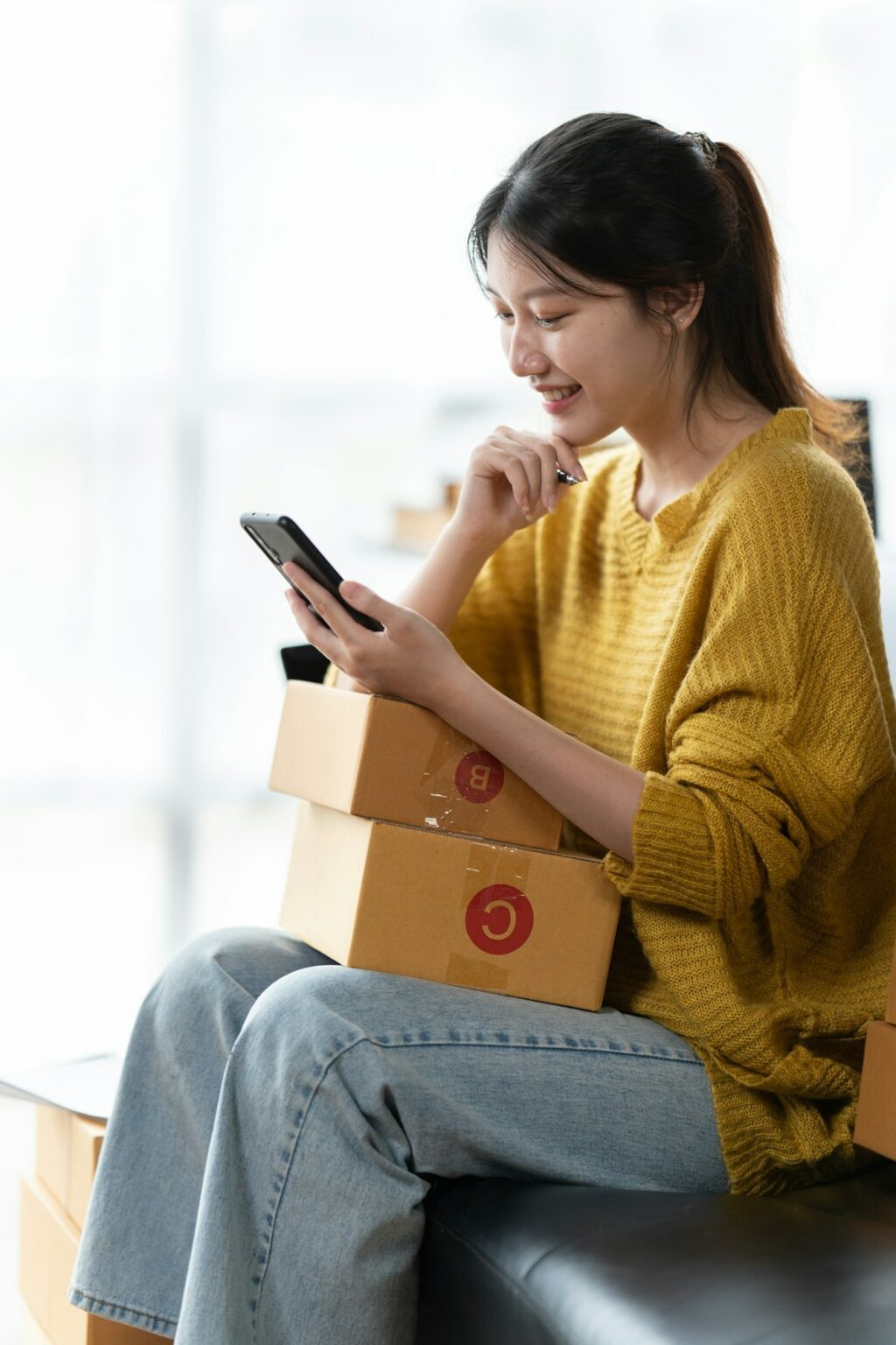 Asian woman business owner works with a box at home, prepare parcel delivery SME supply chain.