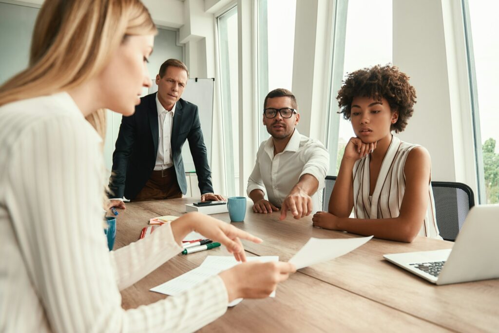 Business meeting. Group of young business people looking at documents and discussing something while