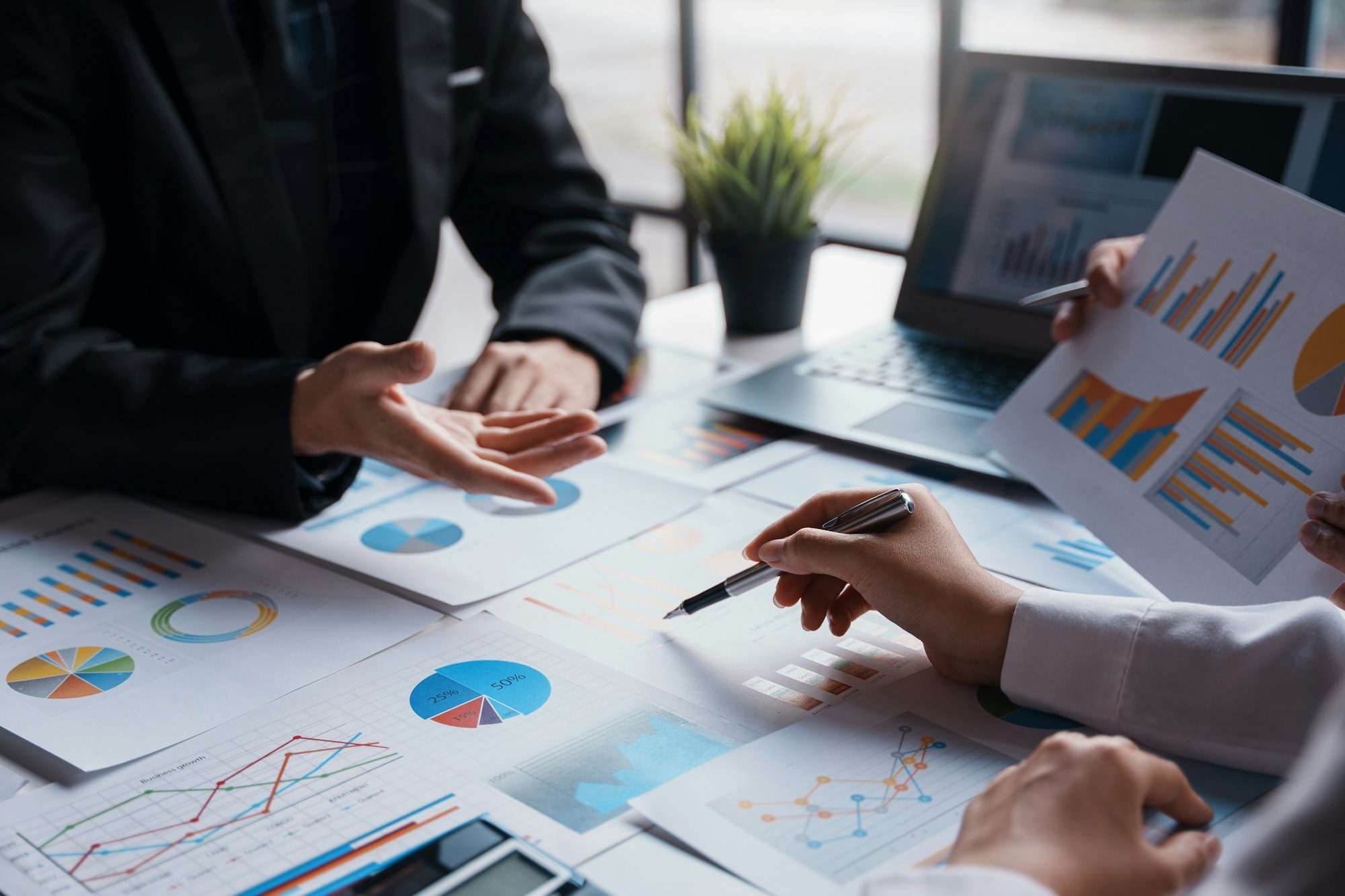 Businessman attending a meeting pointing to a graph to think about market data new product plan